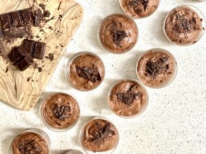 Individual pots of chocolate mouse and a block of dark chocolate with shavings at the side - a recipe for reducing inflammation in the body.