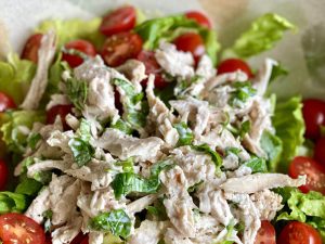 A salad consisting of chicken, basil, lettuce and tomatoes in a dressing, from the anti-inflammatory diet on EBS.