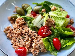 A plate of wild salmon salad with olives, tomatoes, lettuce and other ingredients to boost your mind.