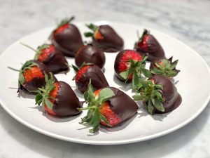 A plate with strawberries dipped into chocolate.
