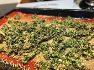 A tray of cheesy kale chips: a healthy homemade snack recipe that is full of anti-inflammatory properties.