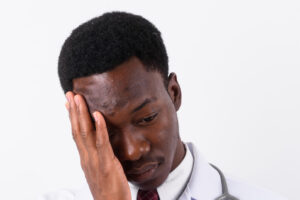 Studio shot of young handsome African man doctor against white background