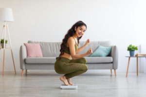 Young Asian lady celebrating her achievement, successful in slimming