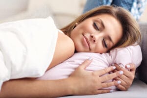 Woman in bed smiling, fast asleep