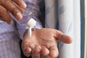 Close up a man's hand and hand sanitiser being used.