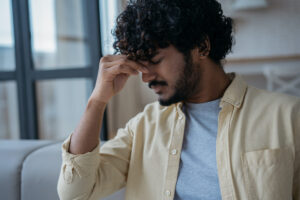 Man with a headache, indicating malnutrition