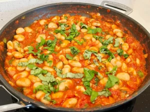 butter bean and tomato stew garnished with basil