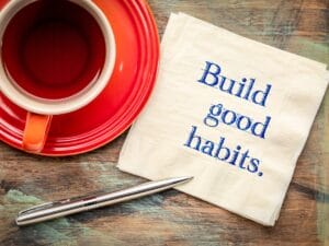 cup of herbal tea and a napkin that says build good habits