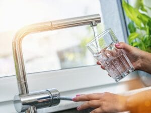 person pouring a glass of water for a new habit
