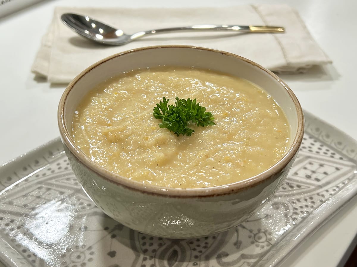 bowl of parsnip soup decorated with curly parsley