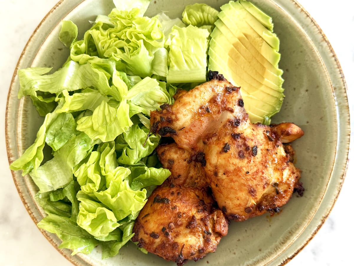 Mexican marinated chicken with a side of slice avocado and salad