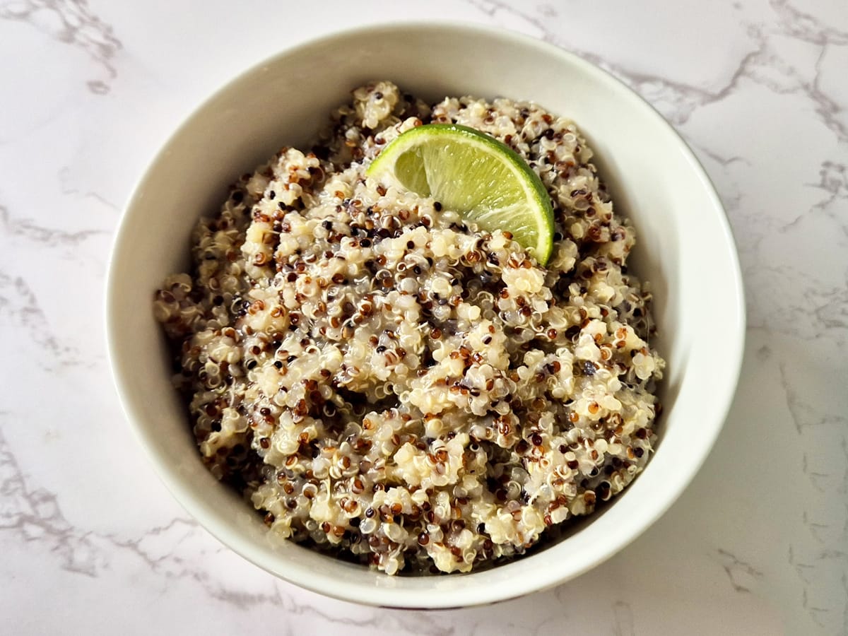 a bowl of miso quinoa served with a wedge of lime
