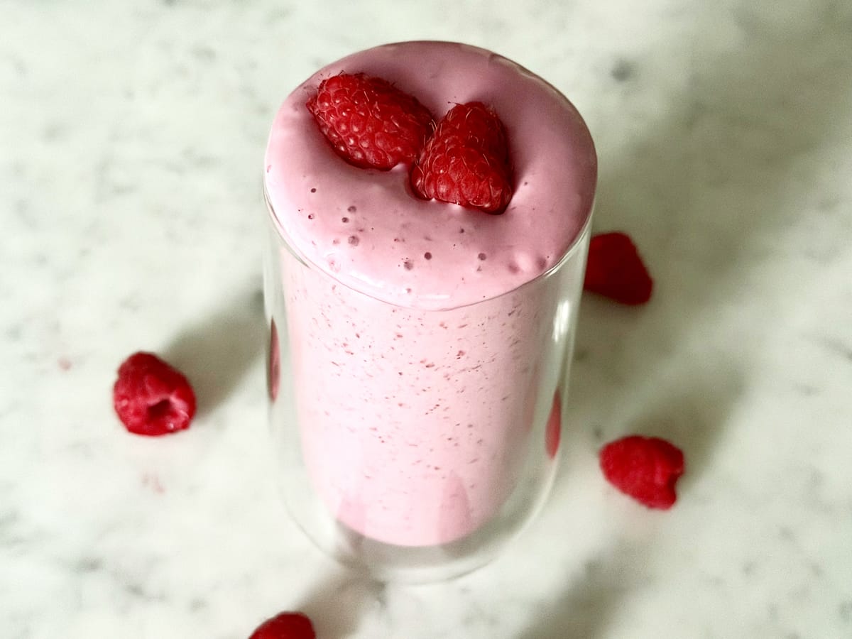 Perimenopause Glow Shake topped with fresh raspberries