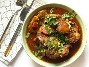 A bowl of Collagen Rich Oxtail Stew garnished with fresh herbs
